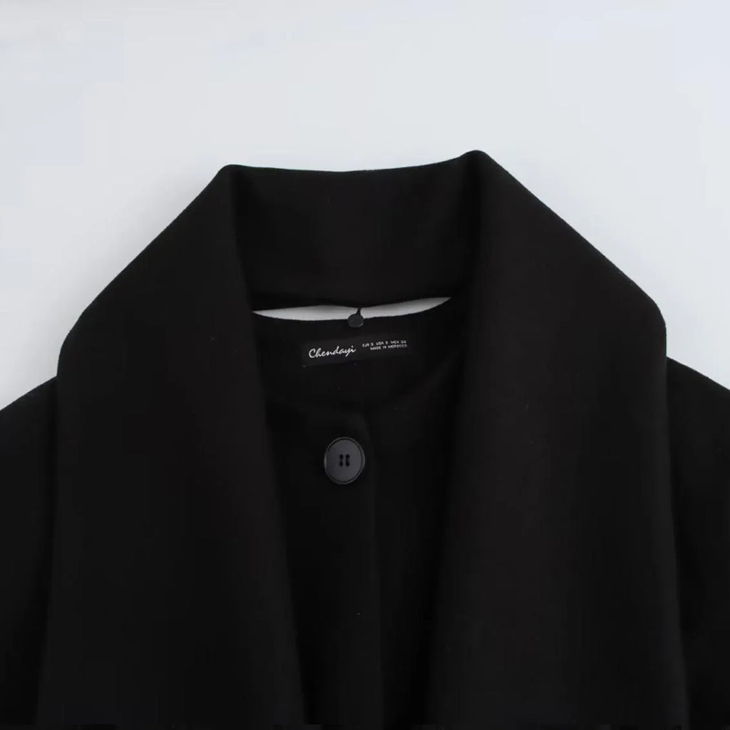 Long grey women's polyester overcoat with a black faux fur collar on a hanger.