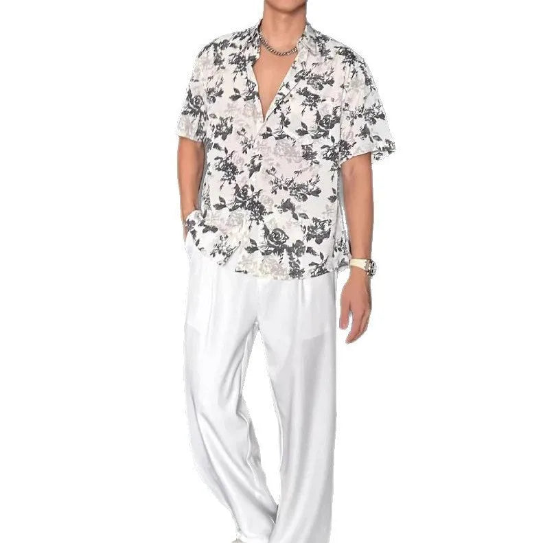 Man wearing a loose black short-sleeve shirt with a floral printed pattern.