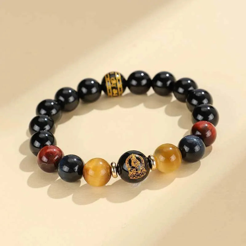 Manually crafted black agate beaded bracelet with gold, blue, and red tiger eye stones, showing ethnic zodiac design.