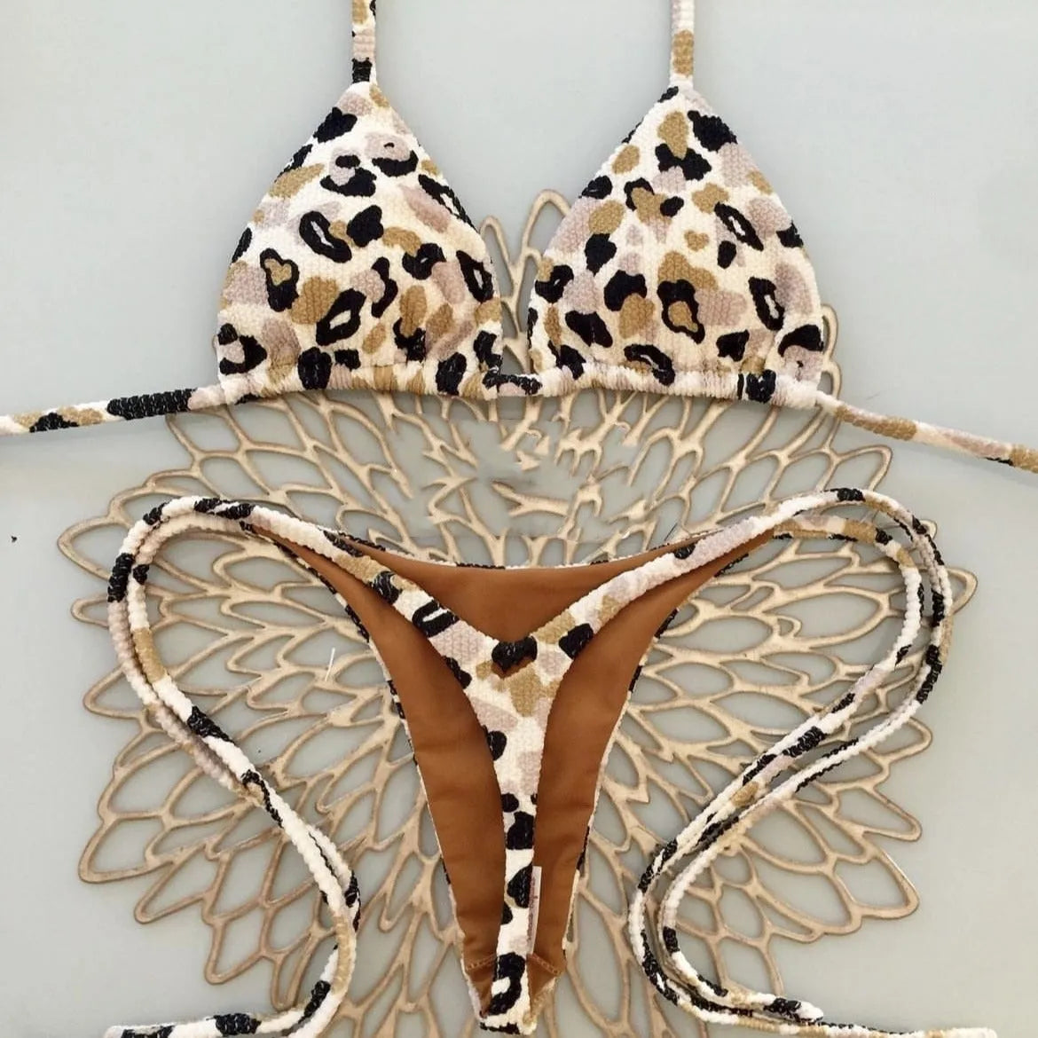 Women's printed bikini swimsuit on a hanger, showing briefs style and cotton lining detail.