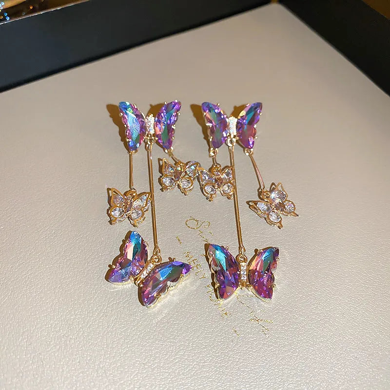 Blue and purple butterfly crystal tassel drop earrings for women on a white background.