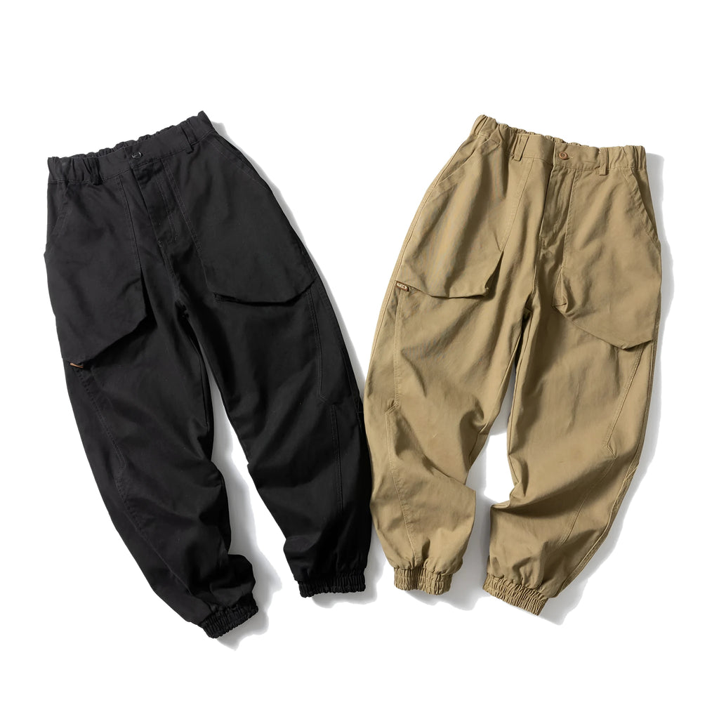 Black cotton tapered casual pants with ankle tie and large pocket.