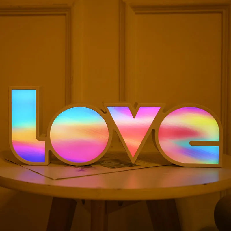 LED Love light with rainbow 'LOVE' lampshade on a table.