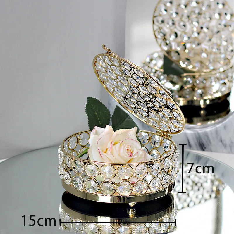 French gold metal jewelry box with a clear crystal glass lid and a lock, shown on a surface.