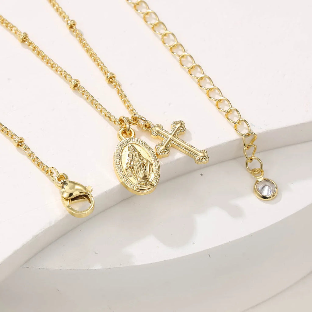 Gold coloured geometric cross necklace with a Virgin Mary ornament pendant for women.
