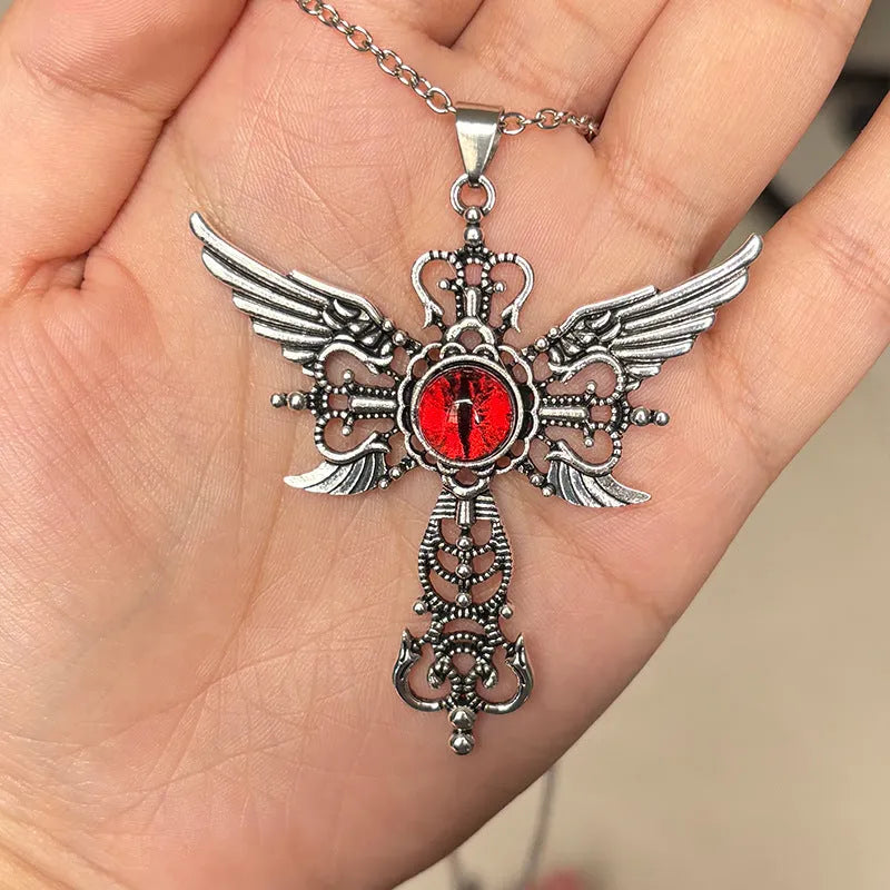 Close-up of a colourful alloy necklace featuring a geometric pendant with devil wings and a cross design.