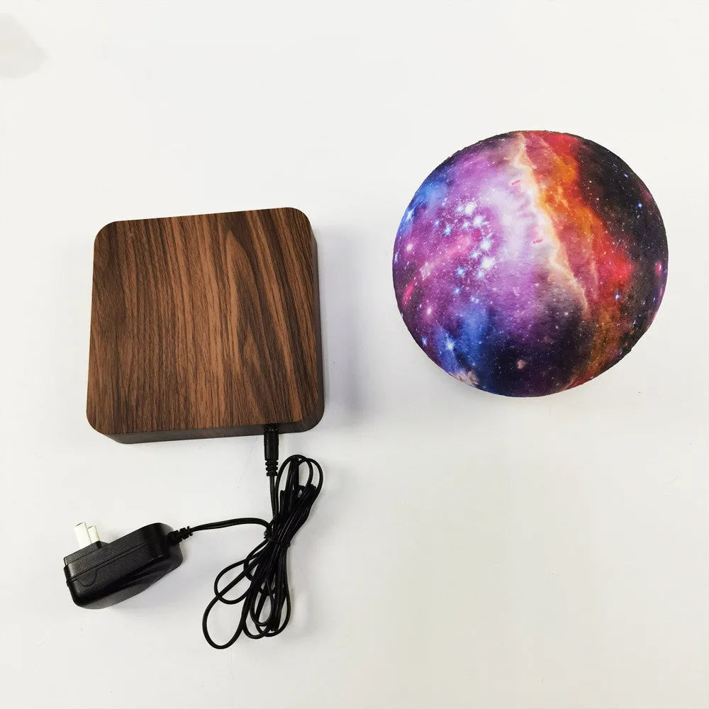 Square walnut coloured levitating moon lamp with galaxy design hovering above a circular base.
