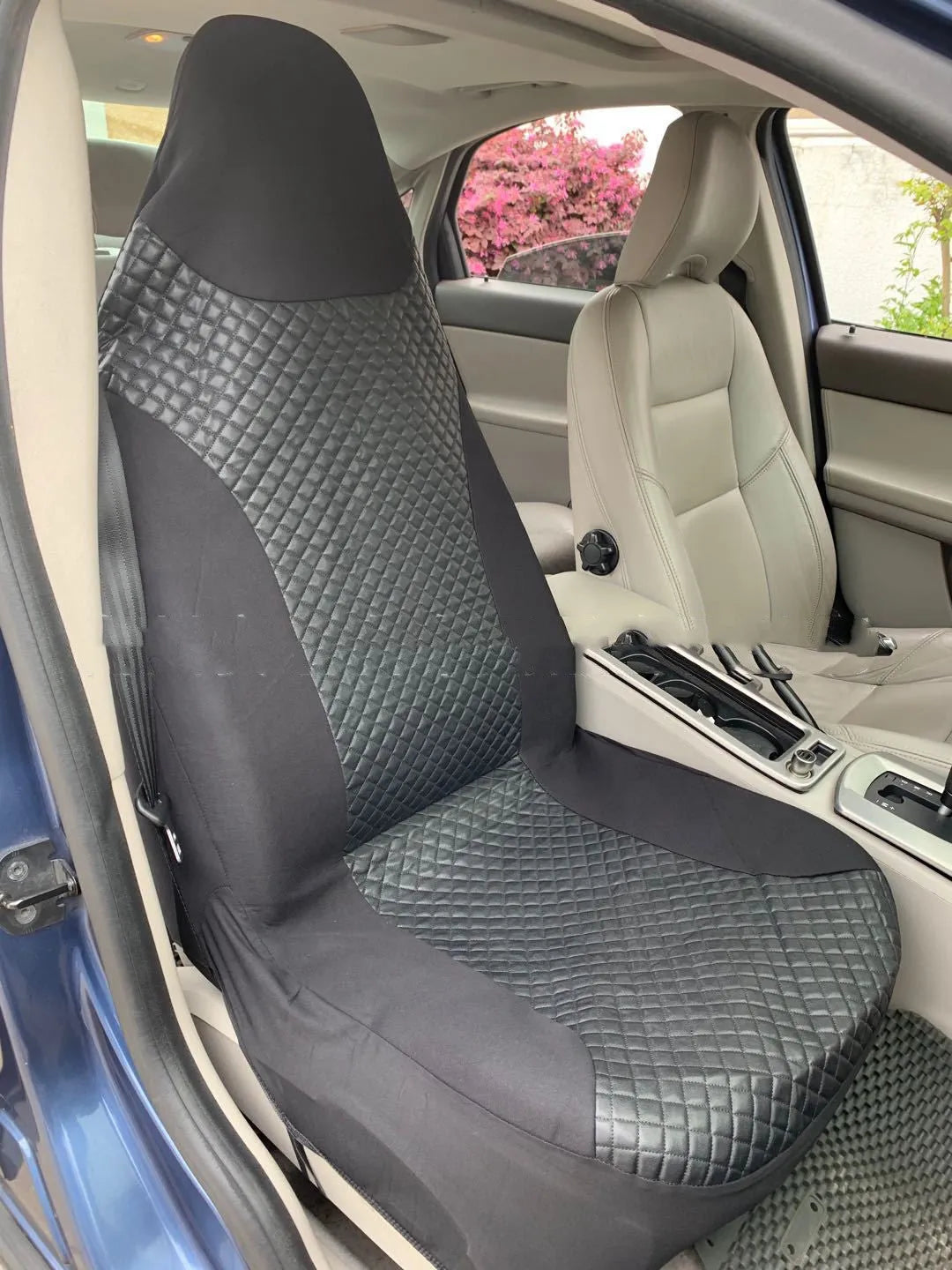 Black quilted universal car seat cover made of PU leather and polyester composite with plastic hooks.