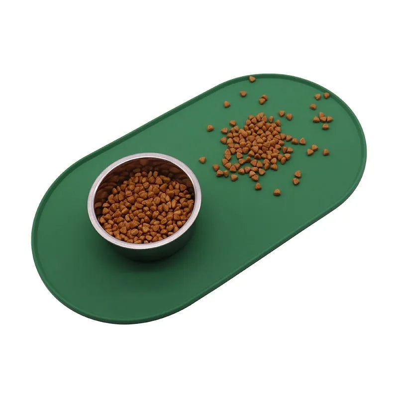 A green silicone placemat for cats with a non-slip base, shown under a food bowl.