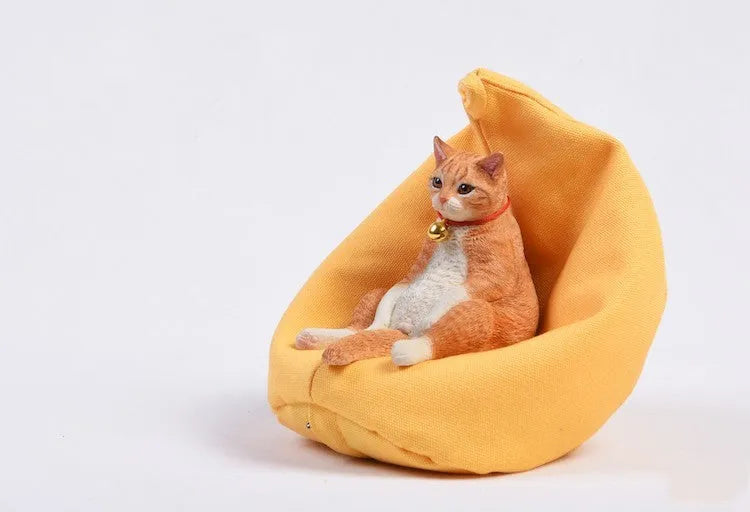 Lazy cat and sofa miniature car dashboard ornament made from resin, approximately 7.5cm high.
