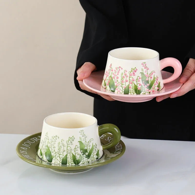 Ceramic coffee cup and saucer set for two with stirring spoons in two design choices.