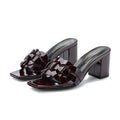 Handmade woven patent leather slipper with sheepskin lining and a chunky rubber sole.