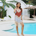 Orange hand-crochet beach overskirt with floral pattern and tassels, part of a matching set
