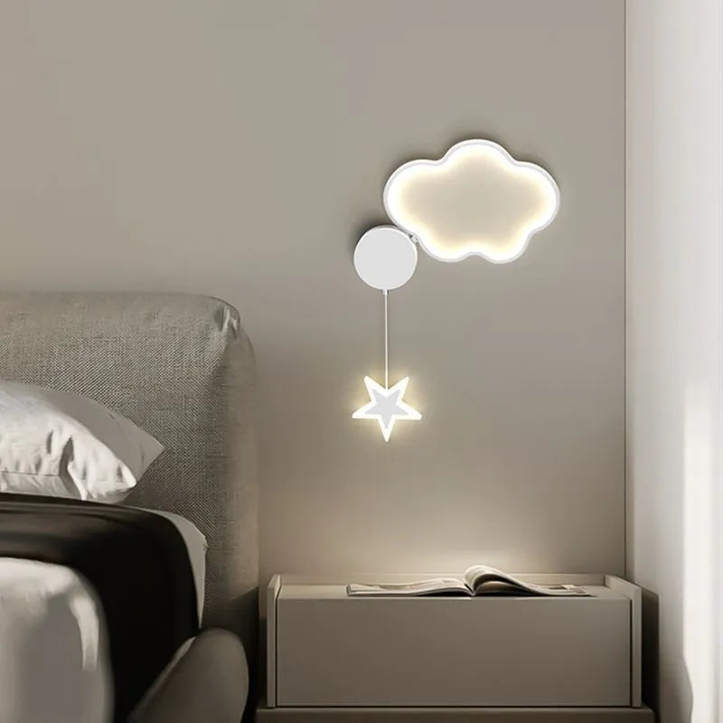 White left-facing cloud children's bedside wall lamp with a three-colour LED light on a bedroom wall.