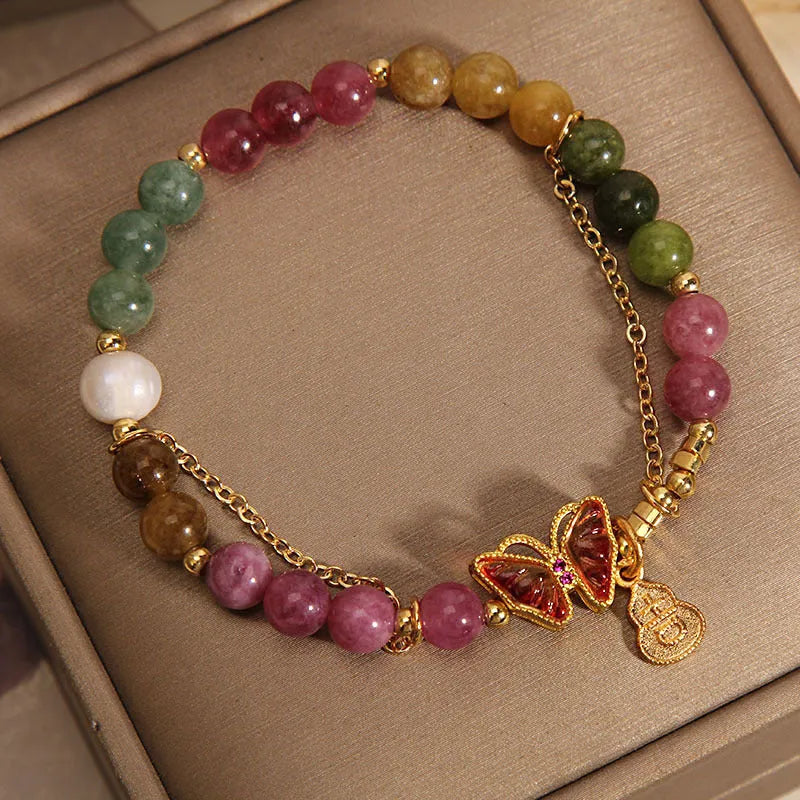 Close-up of a women's agate bracelet with a jade green tourmaline butterfly gourd bead.