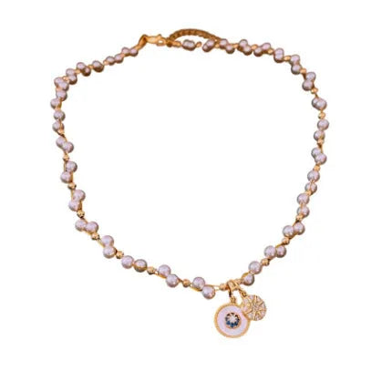 Gold electroplated necklace with round zircon-inlaid imitation pearl pendant on an adjustable clavicle chain.