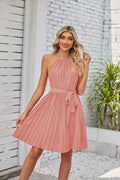 Women's black halter neck chiffon sundress with a pleated midi skirt and waist tie.