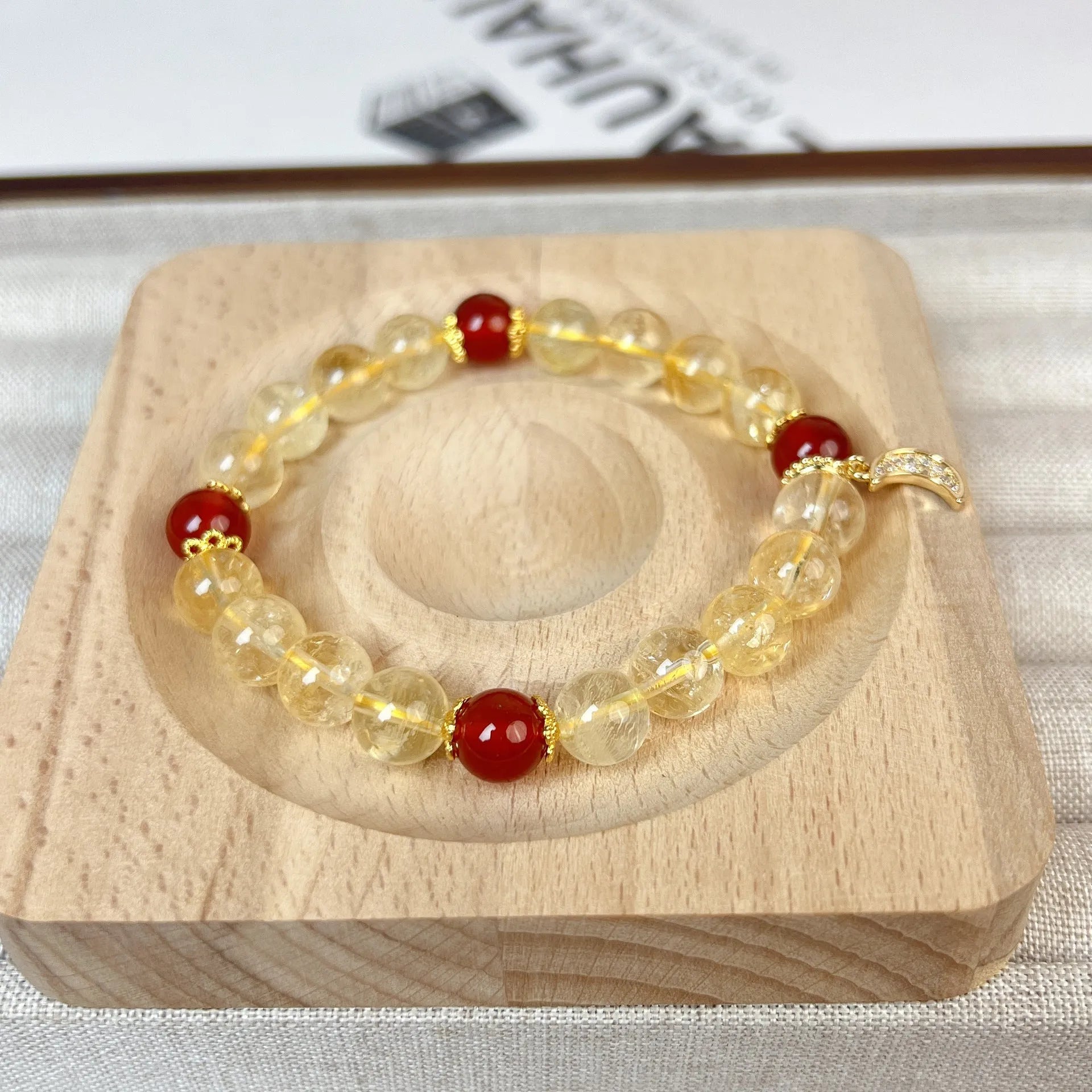 Women's crystal boom bracelet featuring citrine stone, red agate, and central moon design