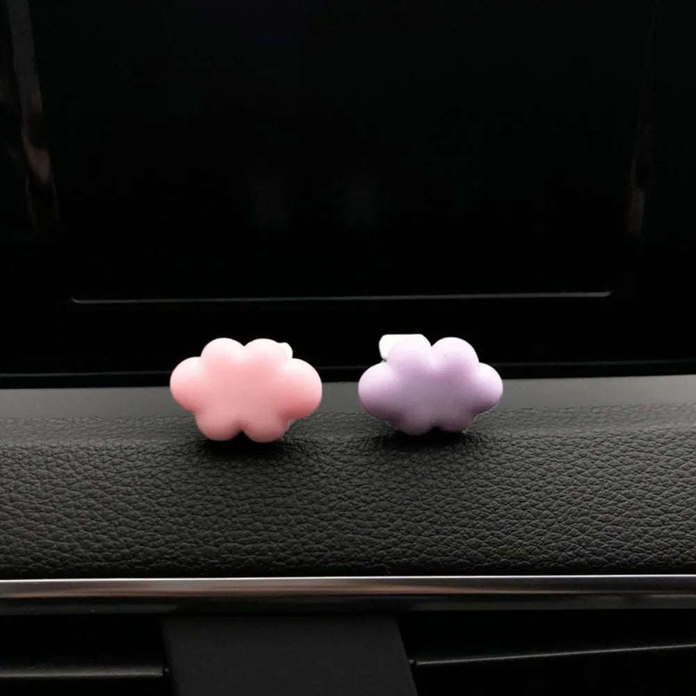 Resin cartoon cloud car air freshener clip in assorted colours on a car vent.
