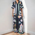 Black women's cardigan and trouser set with cartoon print, showing front view.