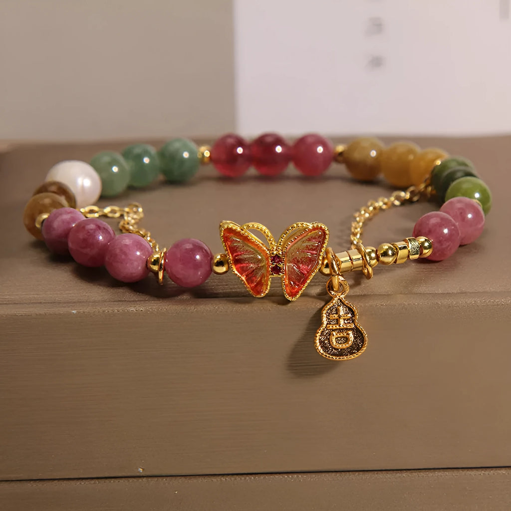 Close-up of a women's agate bracelet with a jade green tourmaline butterfly gourd bead.