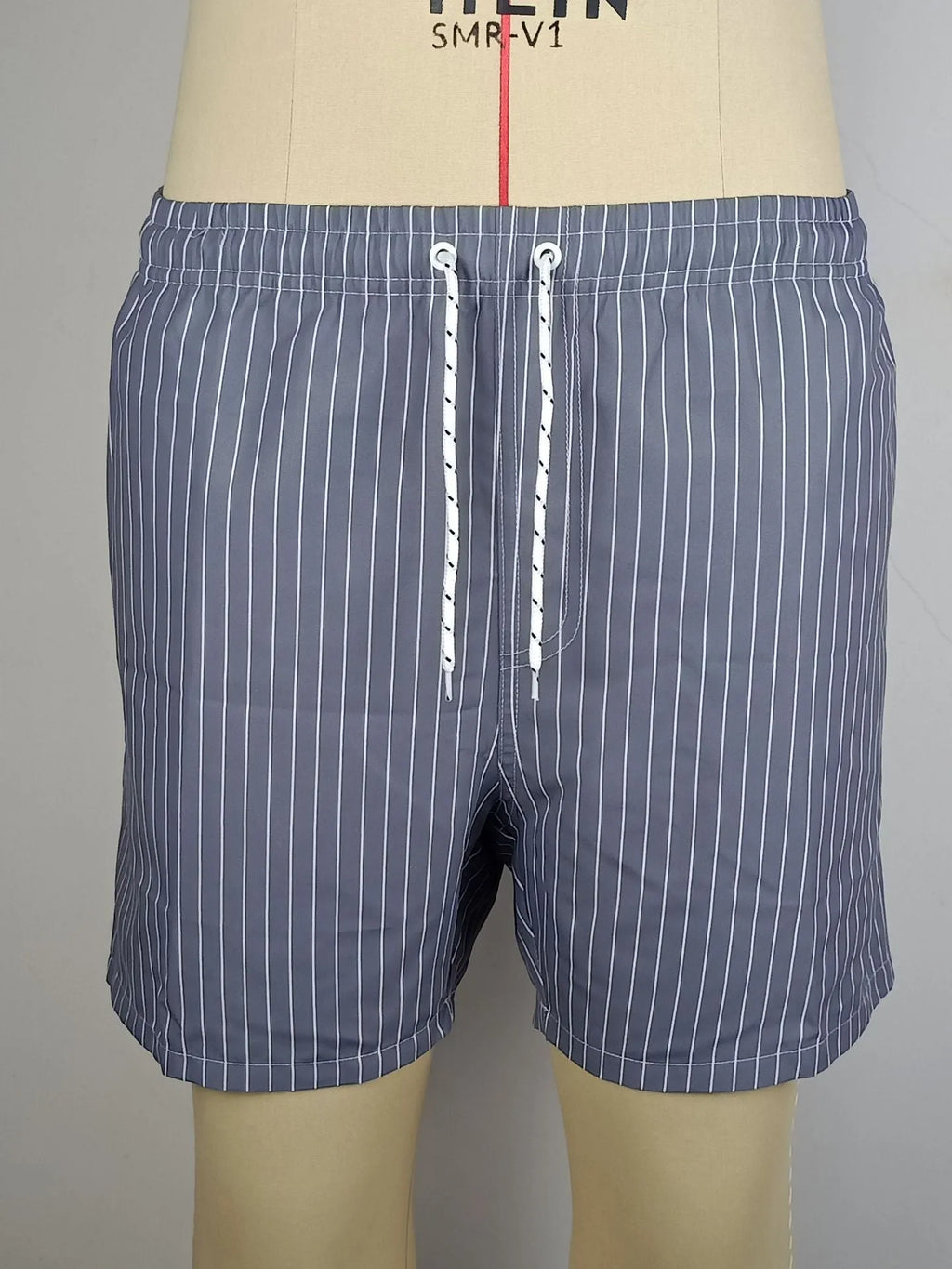 Men's striped polyester shorts in navy blue on a mannequin, showing straight leg design.