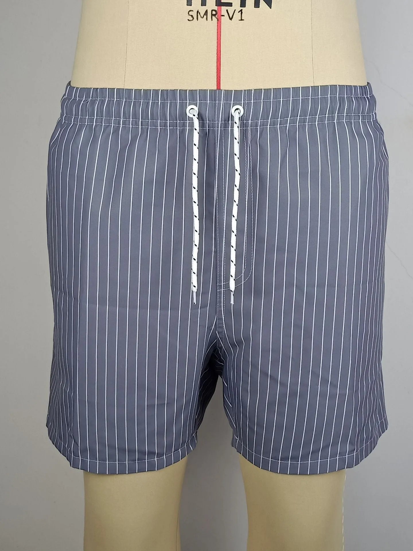 Men's striped polyester shorts in navy blue on a mannequin, showing straight leg design.