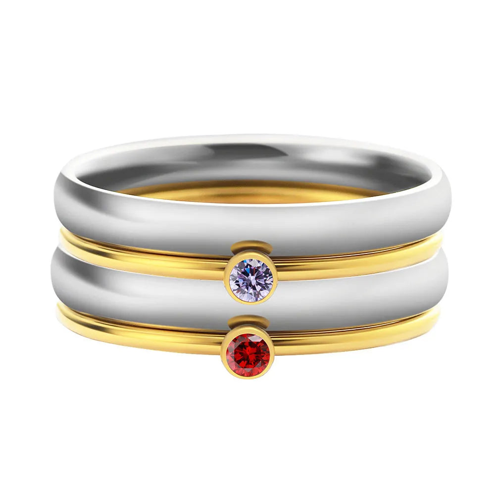 Close-up of a titanium steel ring with an engraved geometric design and a December colour birthstone.