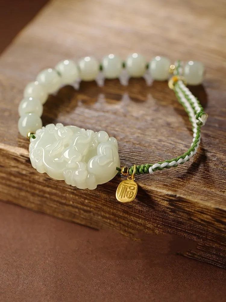 Hetian jade rabbit charm bracelet with sterling silver card on a white ice cotton rope.
