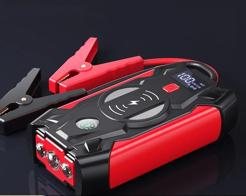 Red car emergency jump starter power pack with connection clips on a black background