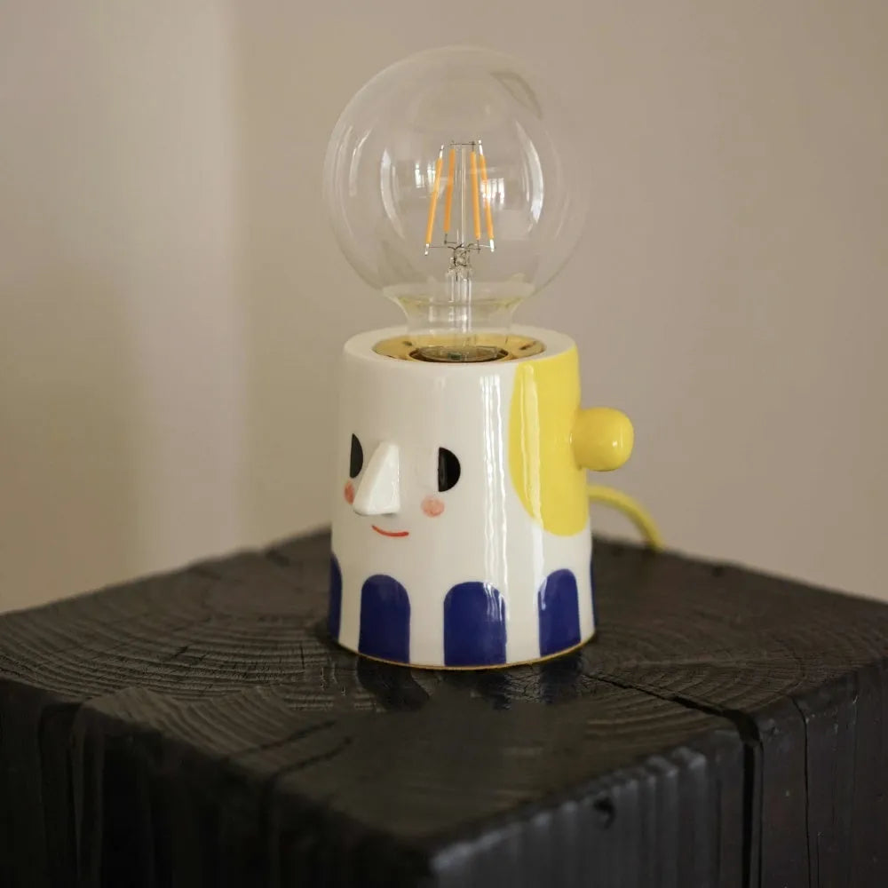 Handmade ceramic bedside lamp with a spherical ball headlight design on a ceramic base.