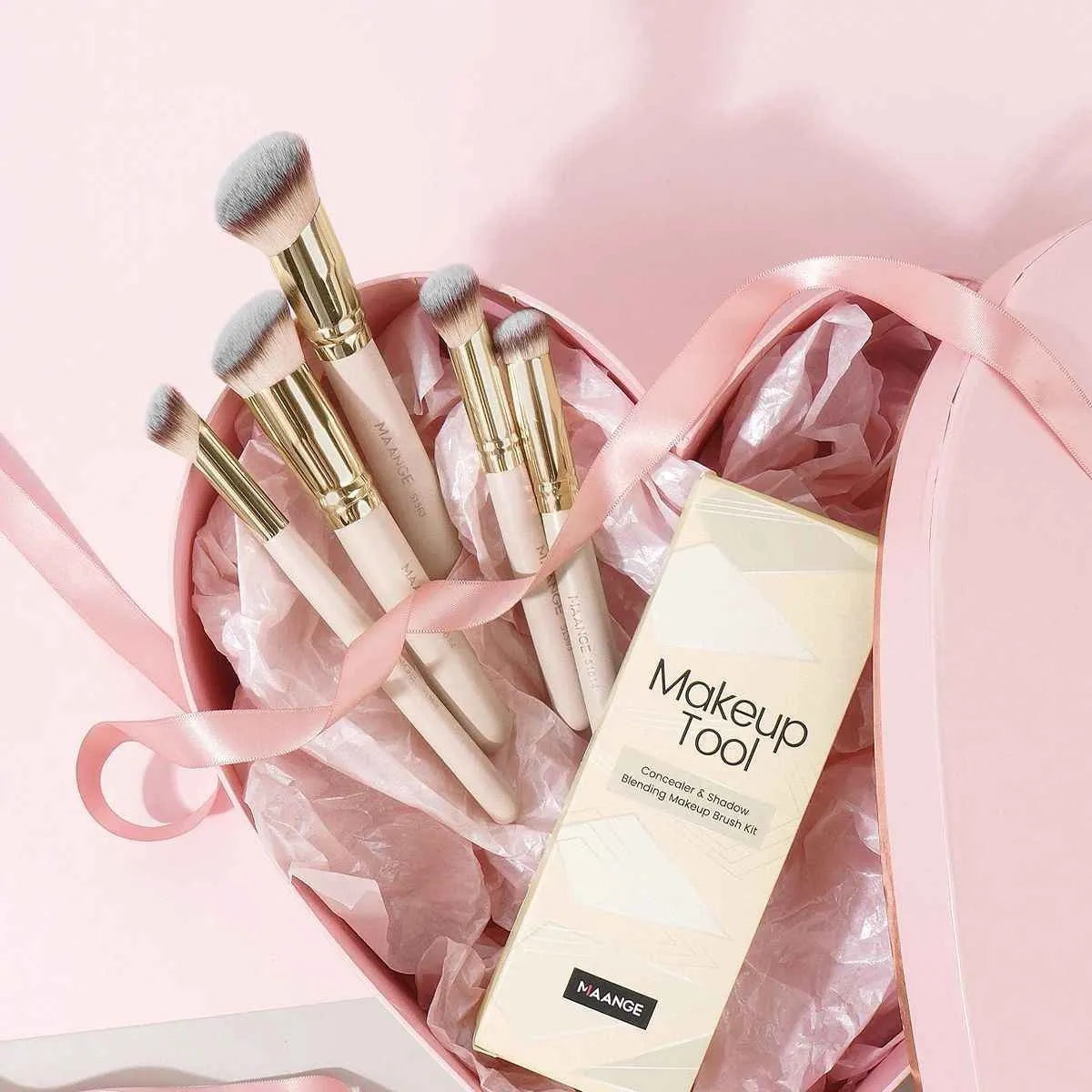 Five apricot-coloured makeup brushes including angled blusher brush for cheek application