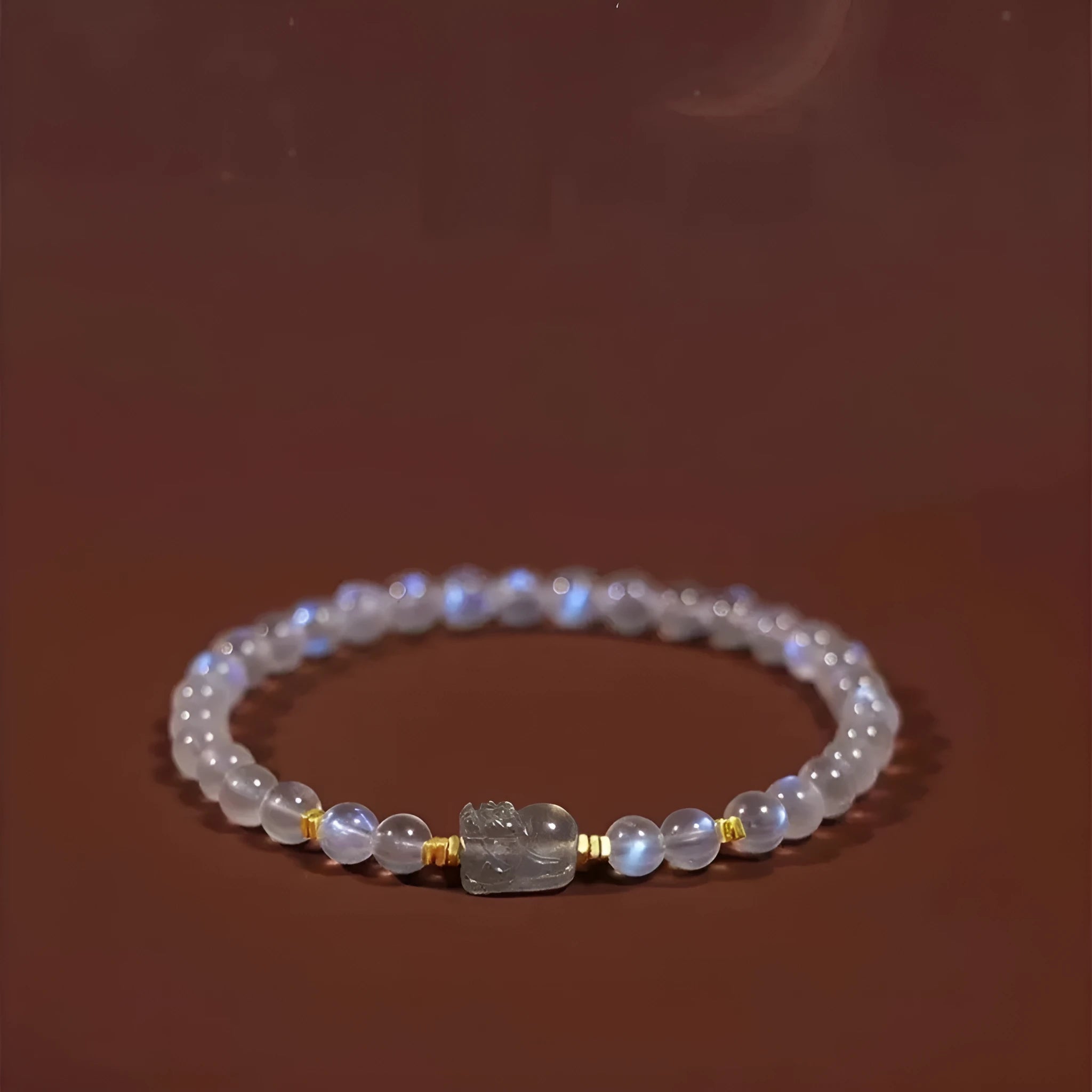 Close-up of a women's moonstone bracelet with zodiac animal design in a traditional Chinese style.