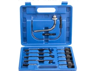 Thirteen-piece automatic transmission oil refuelling kit with pump tool and adapters on a workbench.