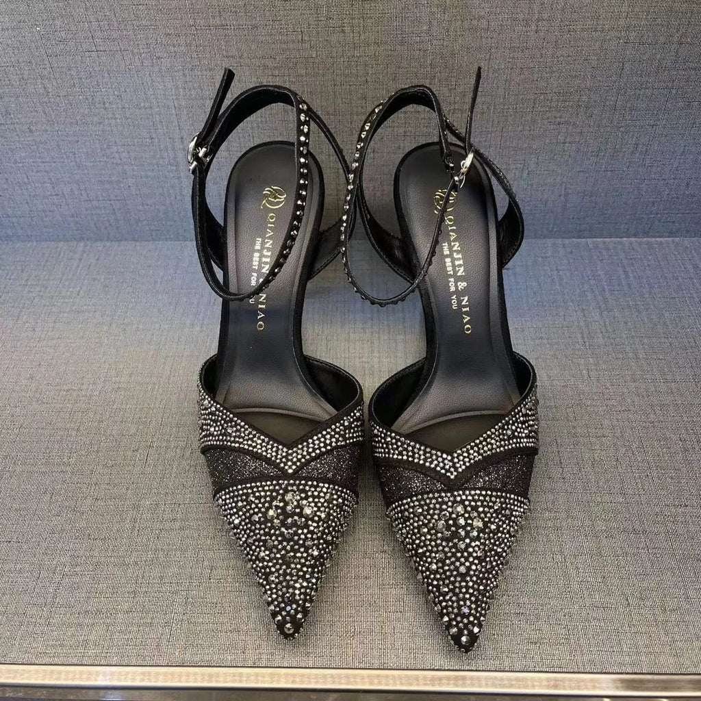 Women's black hollow high heel court shoe with red sole and pointed toe, stiletto heel.