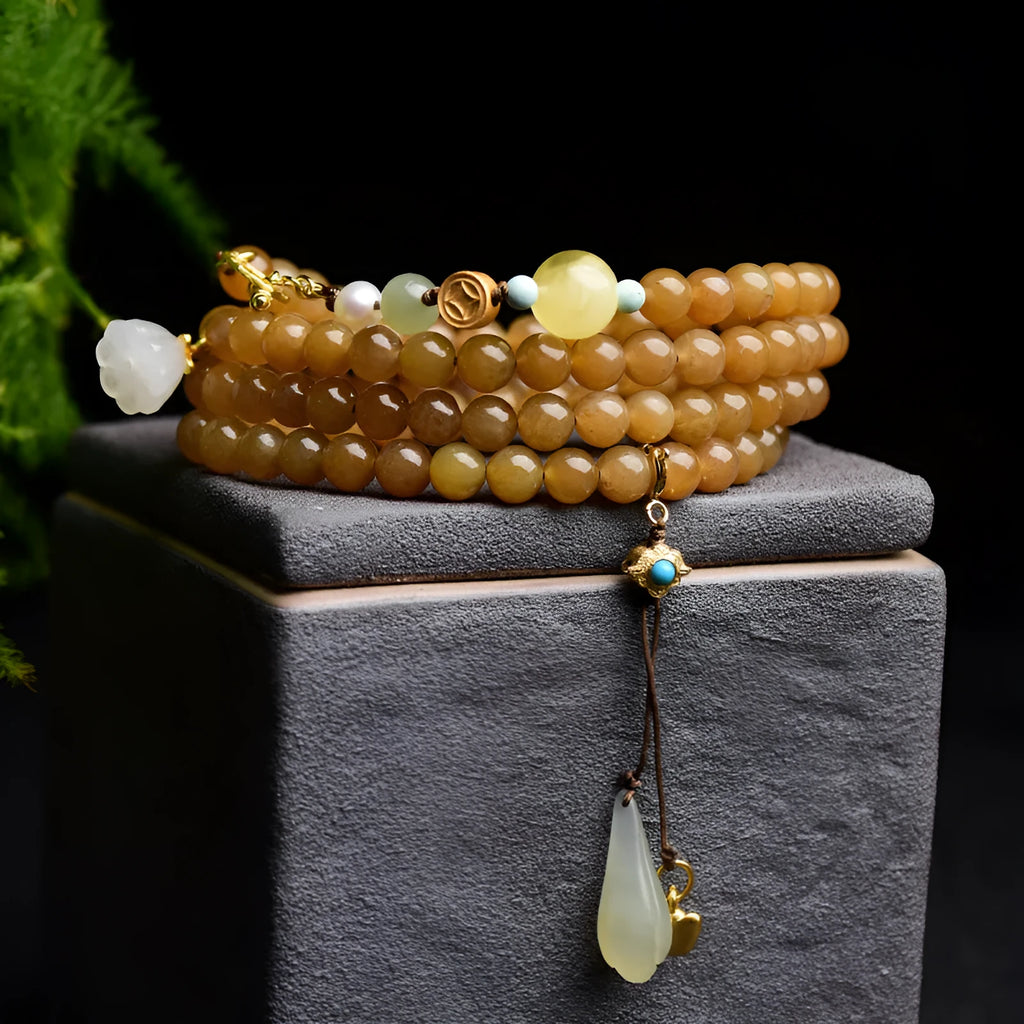 Green jade bracelet with round beads, pine elements, leaf designs, and sequin accents on wrist
