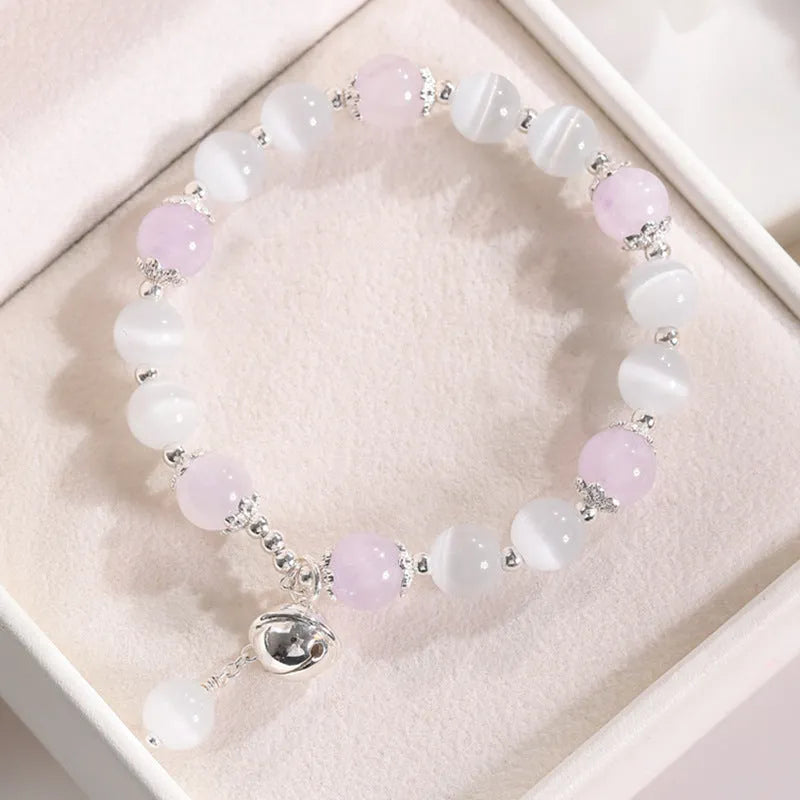 Women's opal cat's eye stone bracelet with diamond-shaped beads on wrist.