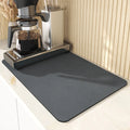 Black square super absorbent PU leather kitchen drain pad drying mat with anti-slip backing on a countertop.