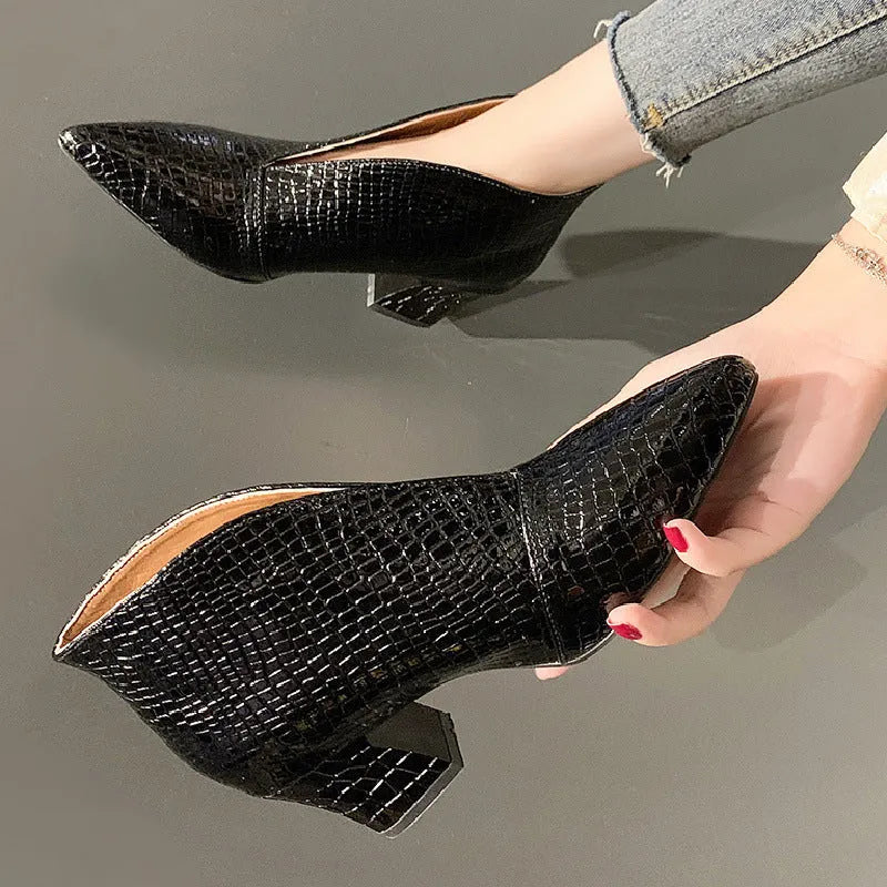 Women's black V-cut pointed toe Martin boots with a chunky heel on a rubber sole
