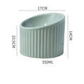 Elevated ceramic cat bowl in light green colour, showing tilted round design for whisker comfort.