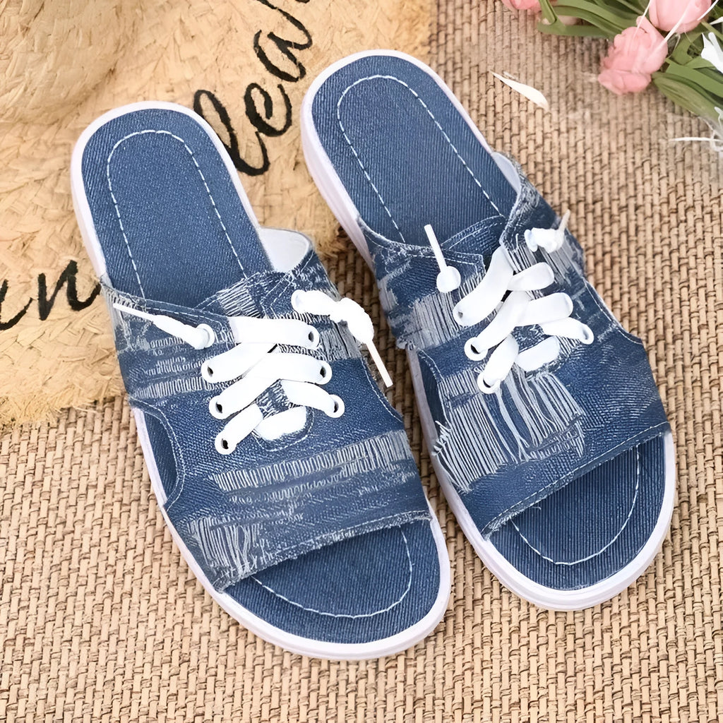 Blue Roman style women's flat canvas slippers with a rubber sole on a plain background.