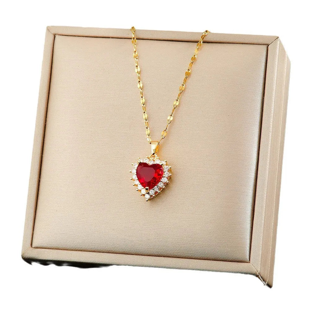 Gold-red titanium steel necklace with heart and flower pendant, matching ear studs, and ring on a white background.