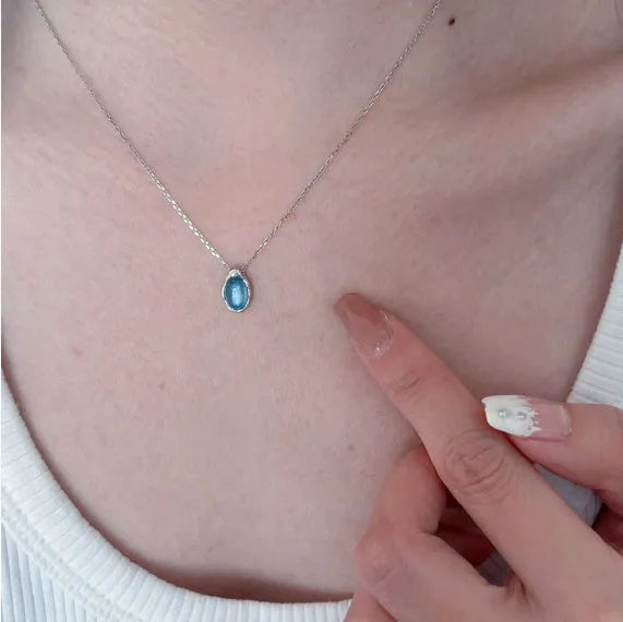 Geometric navy blue and platinum water drop pendant necklace on an adjustable copper cross chain.