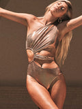 Women's gold backless one-piece swimsuit on a mannequin, showing sleeveless design.