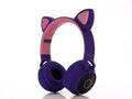 Cartoon-style pink wireless headset with cat ears on the headband, showing Bluetooth connectivity.