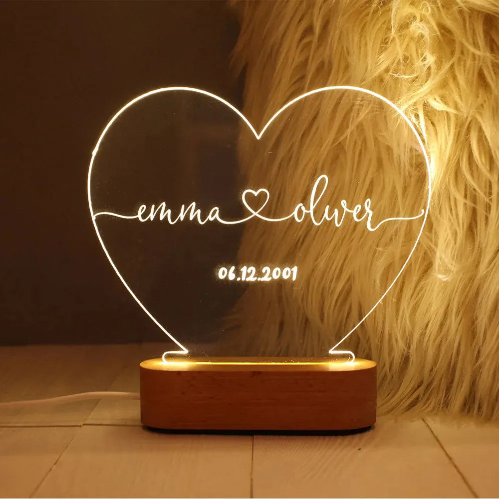 Custom transparent acrylic night light showing personalised names and date, lit by an LED base.