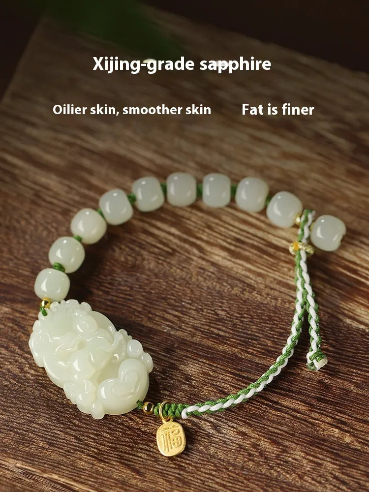 Hetian jade rabbit charm bracelet with sterling silver card on a white ice cotton rope.