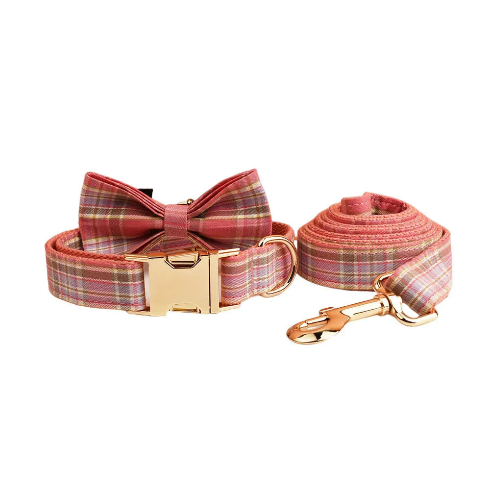 Plaid fabric dog collar, leash, bow, and vest four-piece accessory set on a white background.
