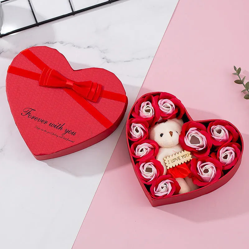 Red heart-shaped gift box open to show pink and red soap roses inside