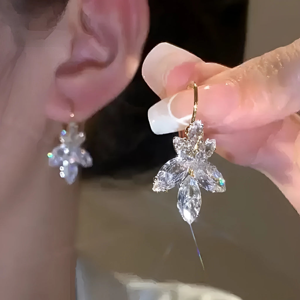 Women's platinum colour leaf earrings with inlaid zircon detailing on alloy background